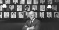 Vincent Sardi in front of a wall of caricatures.
